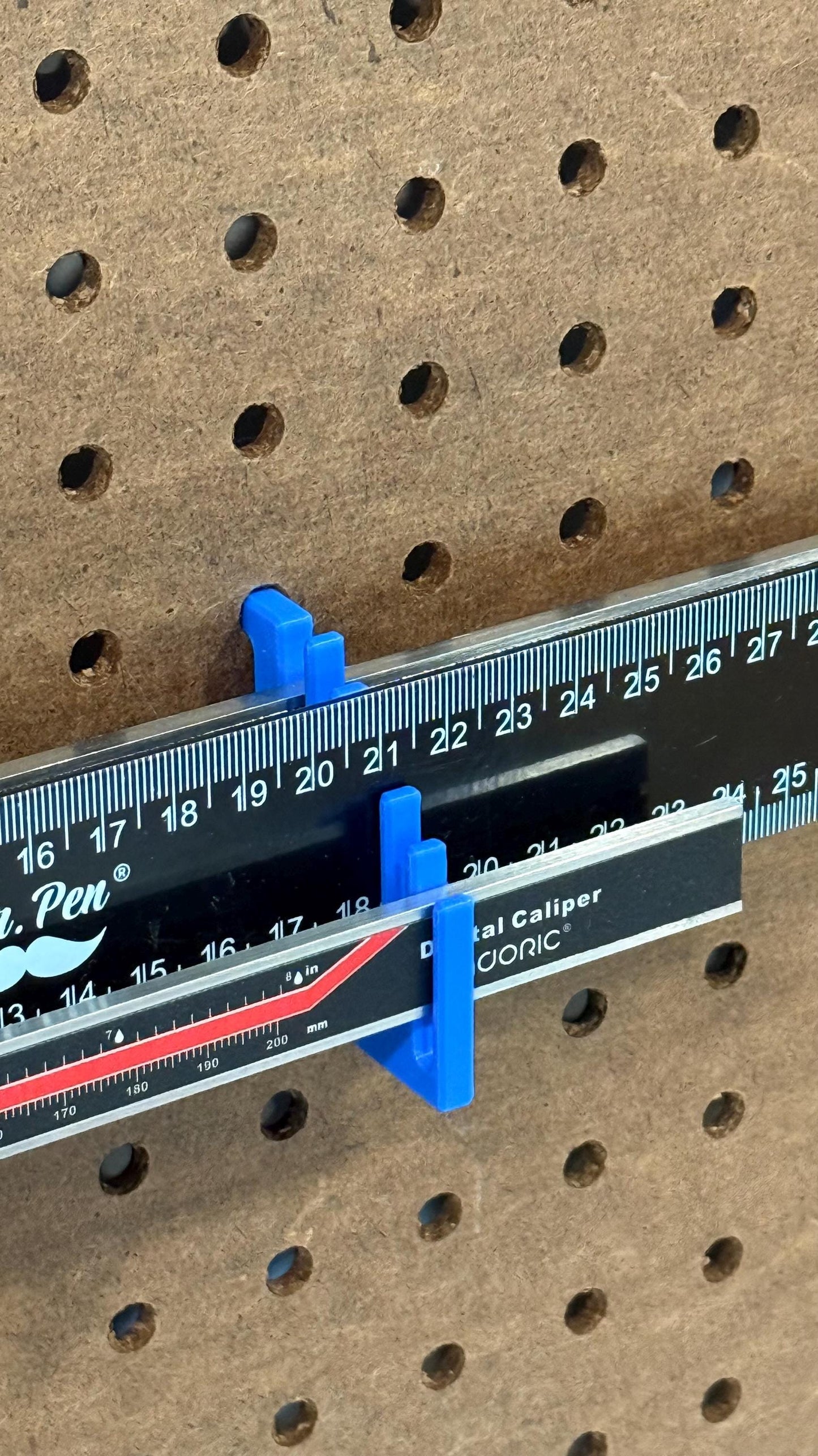 Close up of ruler holder for 1/4 inch pegboard, holes 5